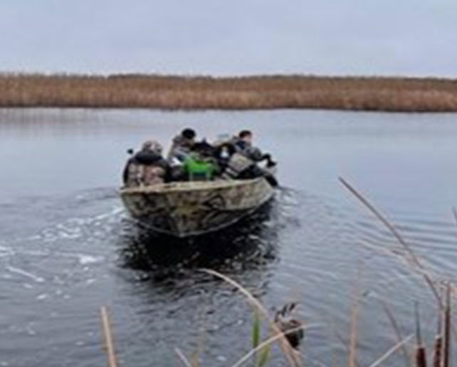 Students travel by boat through marshland for a land-based education program in Bkejwanong Territory.